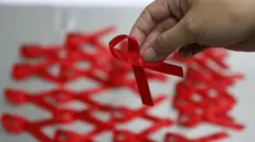 Il fiocco rosso che simboleggia la lotta contro l'Aids - Foto Ansa/Epa Ritchie B. Tongo © www.giornaledibrescia.it