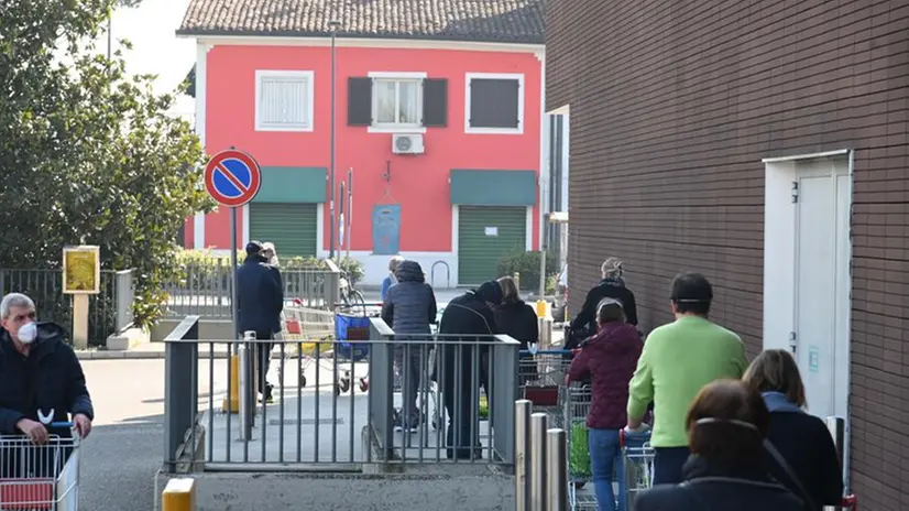 Clienti in coda all'esterno del supermercato
