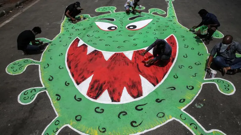 Il coronavirus stilizzato disegnato sulla strada da alcuni artisti -  Foto © www.giornaledibrescia.it