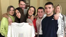 Alcuni studenti e la docente mostrano la maglia del GdB  - © www.giornaledibrescia.it