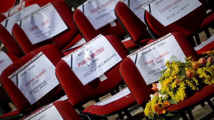 Un flash mob con sedie rosse vuote per ricordare le vittime di femminicidio - Foto Ansa © www.giornaledibrescia.it