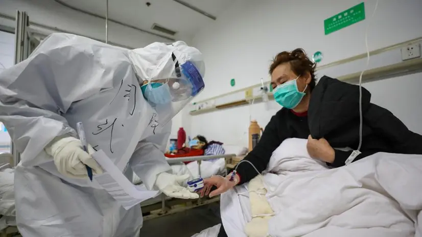 Un medico con un paziente in un ospedale a Wuhan - Foto Ansa/Epa/Yuang Zheng © www.giornaledibrescia.it