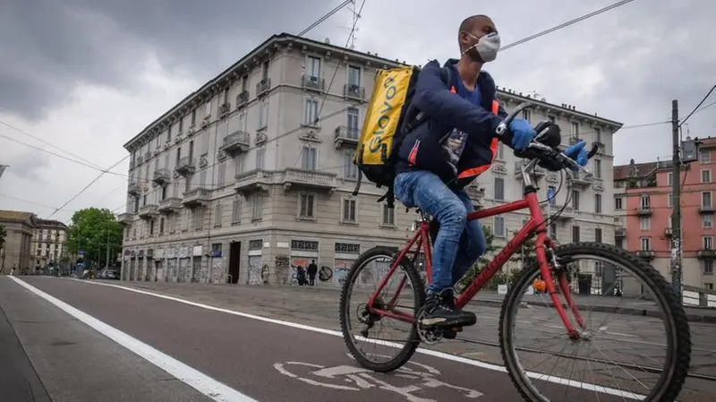 Un rider al lavoro che si sposta lungo una ciclabile - Foto Ansa © www.giornaledibrescia.it
