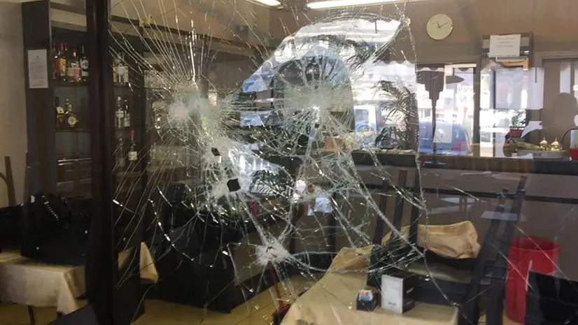 Il vetro distrutto nel raid razzista contro il bar di Rezzato - Foto © www.giornaledibrescia.it