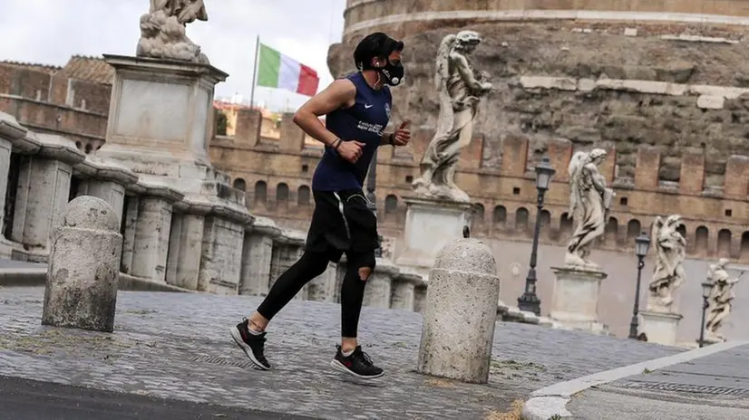 Un runner si allena all'aperto indossando la mascherina - Foto Ansa/Riccardo Antimiani