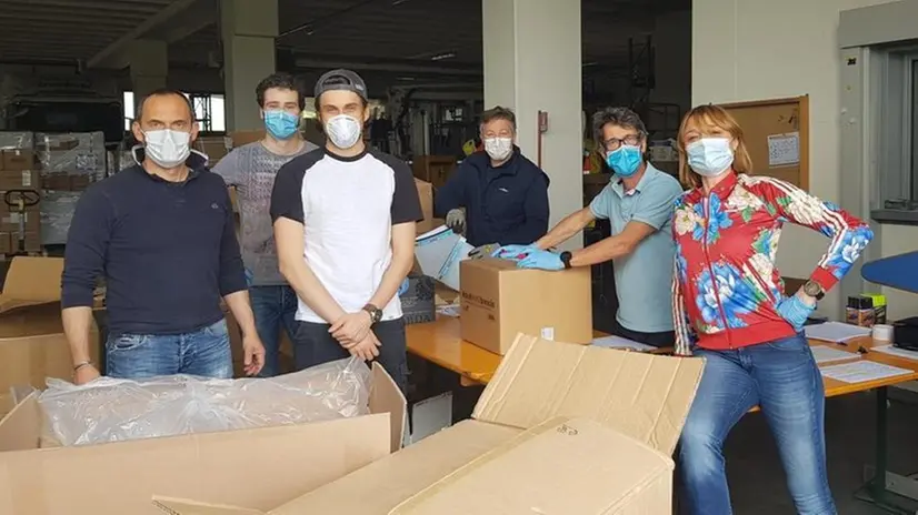 I volontari di aiutiAMObrescia alle prese con il materiale da distribuire nel magazzino di Rezzato - Foto © www.giornaledibrescia.it