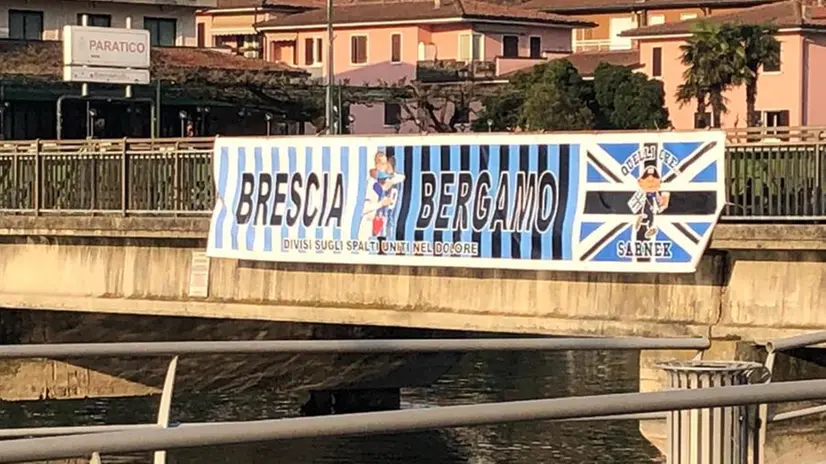 «Brescia e Bergamo: divisi sugli spalti, uniti nel dolore»: lo striscione sul ponte tra Paratico e Sarnico - © www.giornaledibrescia.it