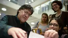 Luis Sepulveda mentre firma autografi per alcune fan - Foto Ansa © www.giornaledibrescia.it