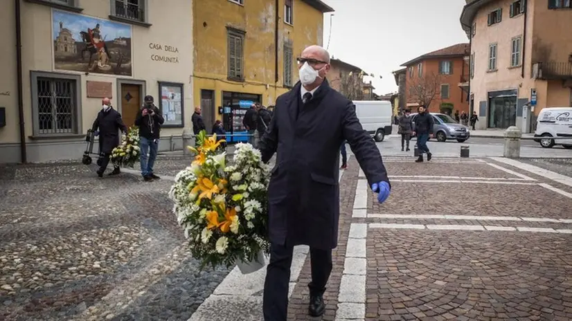 Gli addetti alle pompe funebri si prendono cura dell'ultimo saluto - Foto Ansa/Matteo Conter