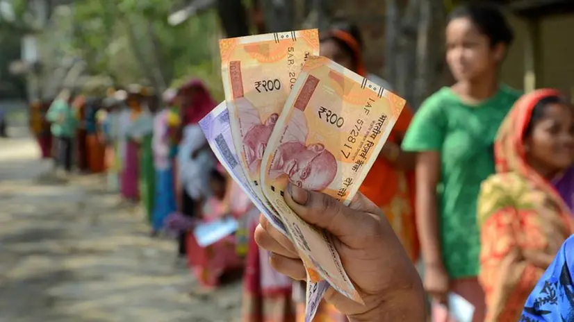 Una donna, in india, mostra Rupie in banconota