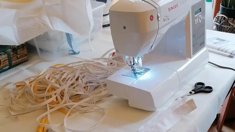 Sarte al lavoro per confezionare le mascherine