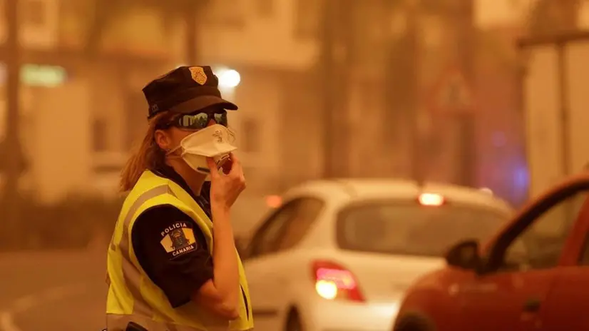 Poliziotta con la mascherina a Tenerife, nelle scorse ore interessata anche da una tempesta di sabbia - Foto Epa / Ansa © www.giornaledibrescia.it