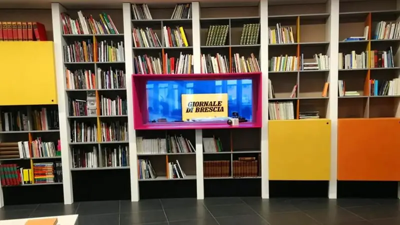 Quasi 300 metri lineari di librerie arredano la rinnovata redazione del GdB: al centro finestra spalancata sul set del tg di Teletutto - © www.giornaledibrescia.it