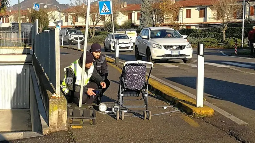 Gli agenti della Locale del Montorfano esaminano il passeggino travolto - © www.giornaledibrescia.it