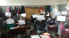 Alcuni bambini di Damasco mostrano i disegni realizzati per il calendario