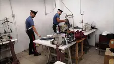 Carabinieri durante un controllo in un laboratorio tessile
