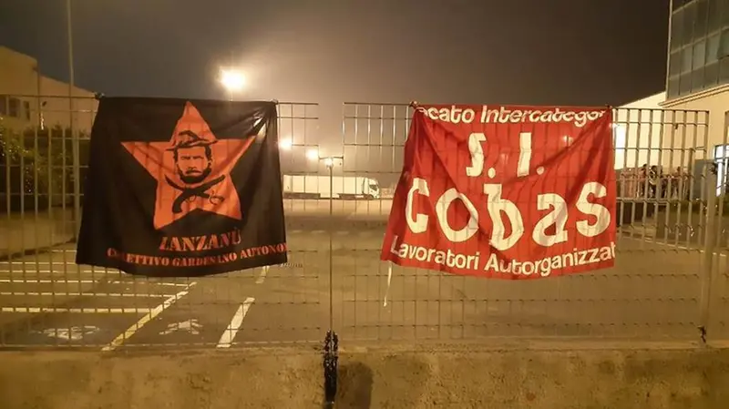 Bandiere del Collettivo gardesano autonomo e del S.I. Cobas - Foto © www.giornaledibrescia.it