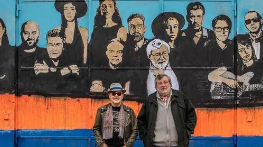 Mauro Pagani e Francesco Guccini a Bologna posano davanti al murale che fa da copertina di  «Note di Viaggio» - © www.giornaledibrescia.it