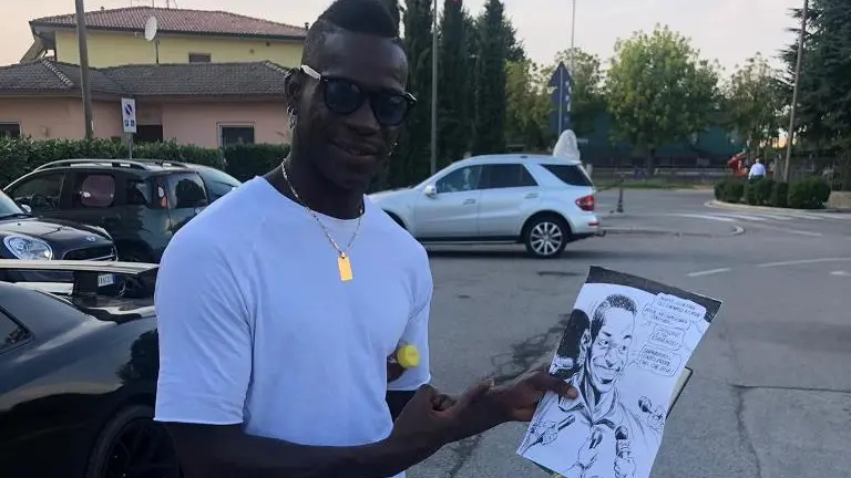 Mario Balotelli con la vignetta disegnata da Gigi Simeoni - Foto Ansa © www.giornaledibrescia.it