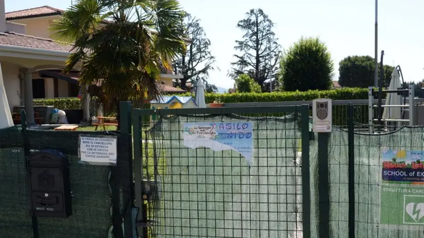 Cartello strappato all'ingresso dell'asilo al centro dell'inchiesta per maltrattamenti a Rodengo Saiano - © www.giornaledibrescia.it