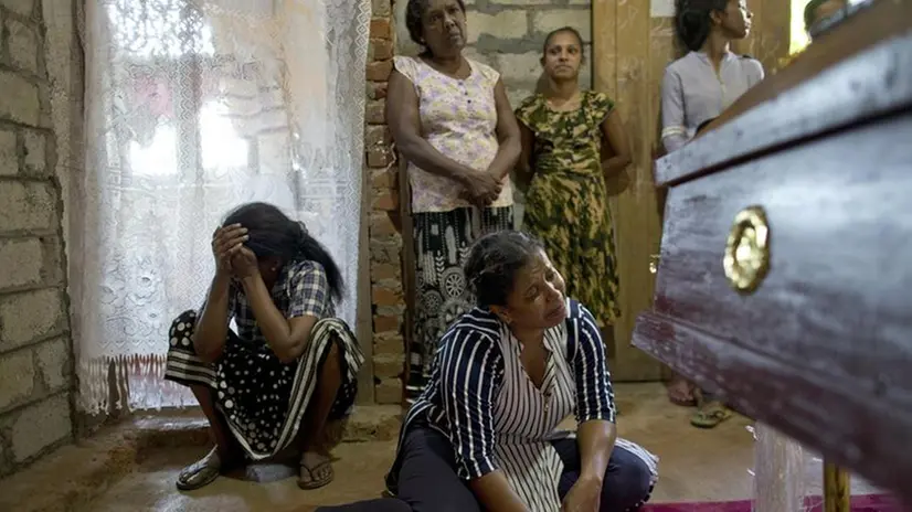 Una famiglia piange una delle vittime degli attentati - Foto Ansa/Ap Gemunu Amarasinghe © www.giornaledibrescia.it