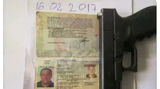 Foto diffusa dai sequestratori con passaporto di Zanotti e una pistola © www.giornaledibrescia.it