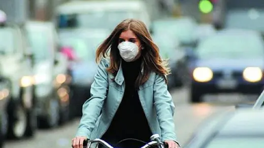 Una ciclista alle prese con lo smog - © www.giornaledibrescia.it