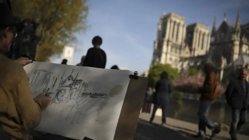 Un artista mentre realizza il disegno della cattedrale di Notre-Dame - Foto Ansa/Ap Francisco Seco © www.giornaledibrescia.it