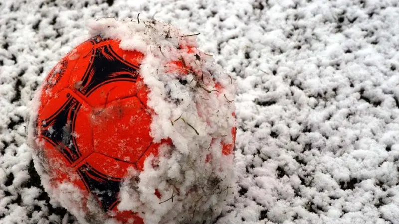 Un pallone sul campo di calcio innevato