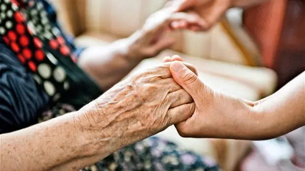 Una stretta di mano tra un'anziana e una giovane - Foto di repertorio