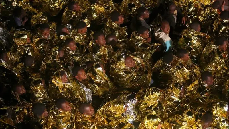 Migranti avvolti nelle coperte termiche dorate - Foto Francesco Malavolta © www.giovannidegara.org