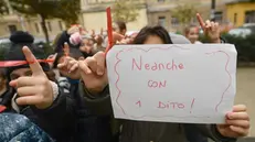 La manifestazione delle alunne di una scuola elementare genovese in occasione della Giornata contro la violenza sulle donne - Foto Ansa/Luca Zennaro