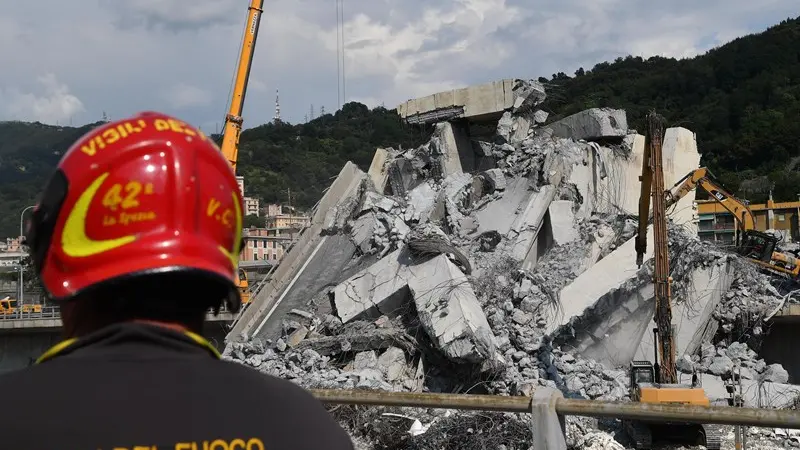 Un vigile del fuoco davanti alle macerie del Ponte Morandi - Foto Ansa/Luca Zennaro