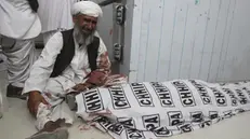 Un uomo piange davanti al corpo di un familiare morto durante l'attentato - Foto Ansa/Ap Arshad Butt