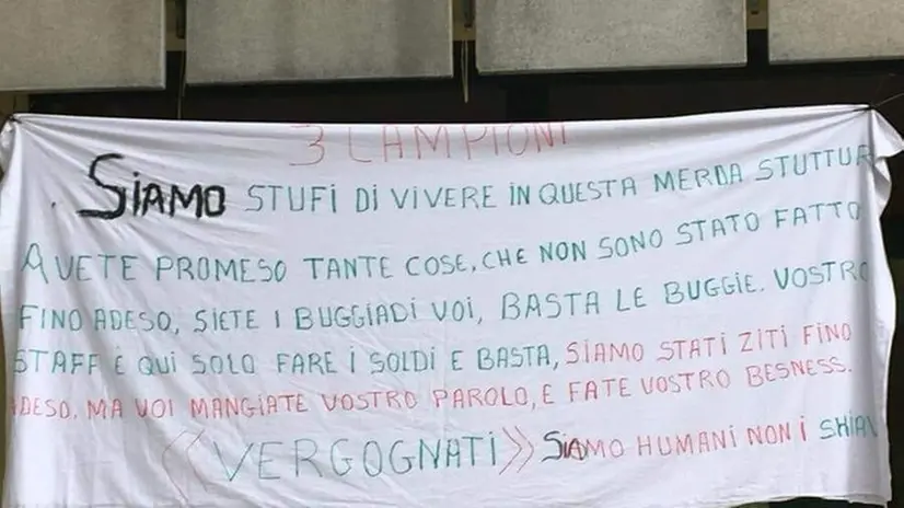 Il cartello esposto dai rifugiati che è stato fatto rimuovere dalle forze dell’ordine