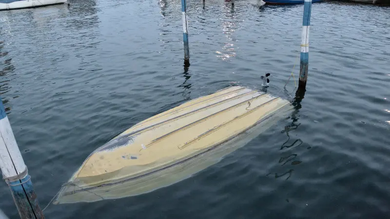 La barca ribaltata recuperata nel porto di Iseo