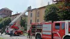 Le squadre dei Vigili del fuoco al lavoro per domare le fiamme sul tetto della palazzina © www.giornaledibrescia.it