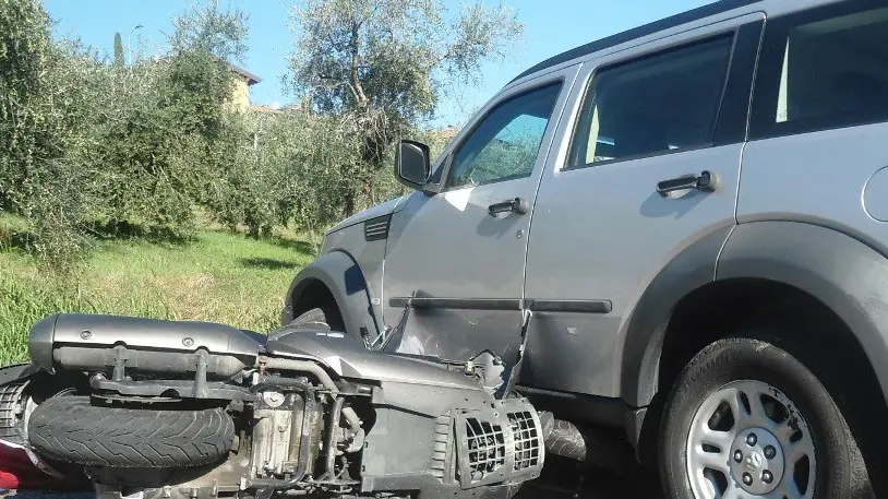 Lo scooter della vittima incastrato sotto l’automobile - Foto  © www.giornaledibrescia.it