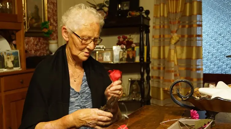 Una signora di Gianico alle prese con la realizzazione dei fiori per l'attesissima festa del 2019