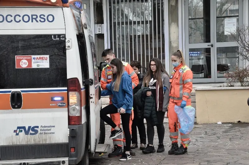 Alcuni degli studenti vengono condotti sull'ambulanza