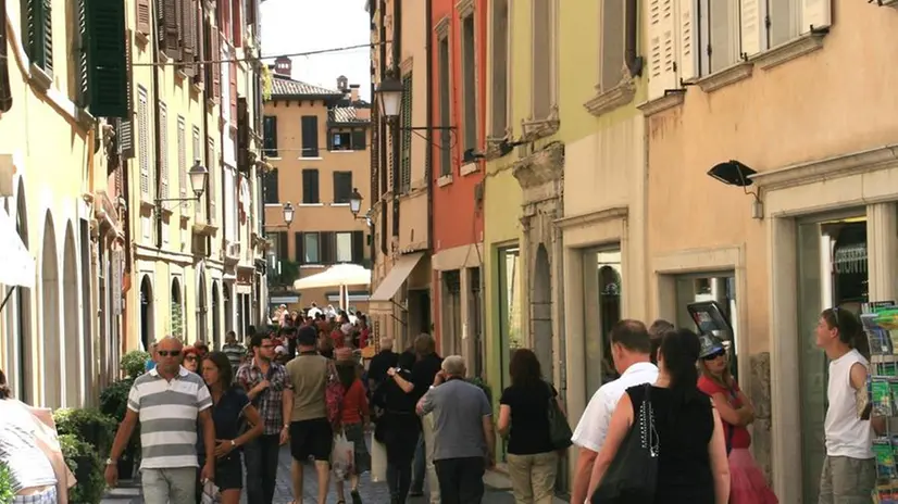 A passeggio. Turisti in via San Carlo, nel cuore di Salò