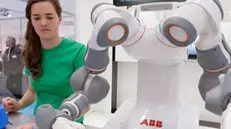 In fabbrica.  Un cobot (un robot collaborativo) lavora fianco a fianco in una postazione di assemblaggio