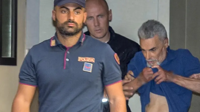 Maurizio Diotallevi con gli agenti di Polizia - Foto Ansa/Claudio Peri