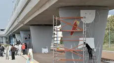 Al lavoro. Ponteggi allestiti e artisti all’opera sui piloni del metrò a Sanpolino
