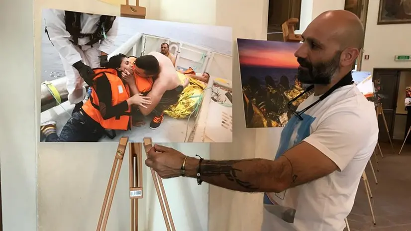 Francesco Malavolta a Brescia davanti alla foto "Il bacio dopo il naufragio"