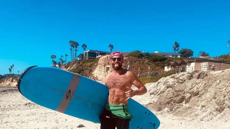 Su una spiaggia californiana con la tavola da surf