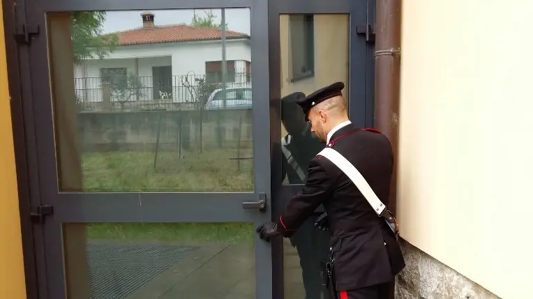 Un carabinieri mostra la porta forzata dal ladro distratto