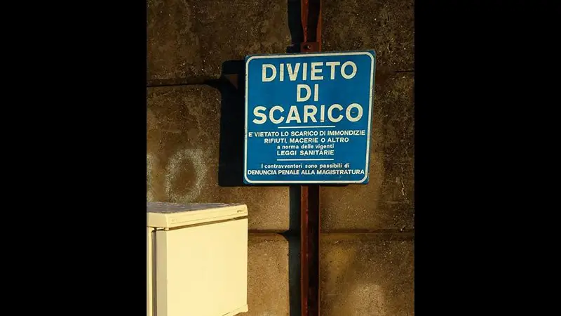 Il frigo abbandonato sotto il cartello di divieto scarico