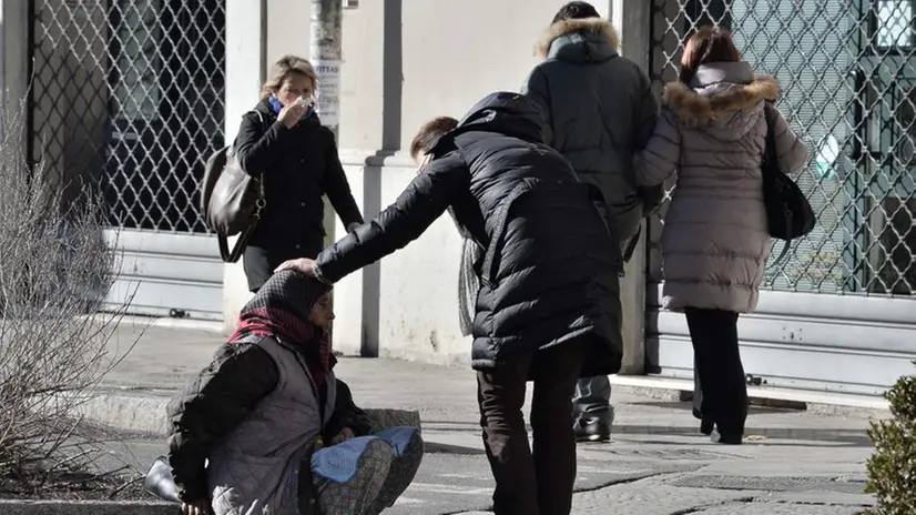 La passante accarezza la mendicante
