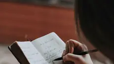 Una ragazza scrive sul diario - Foto Unsplash